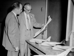 Two men examining airplane model