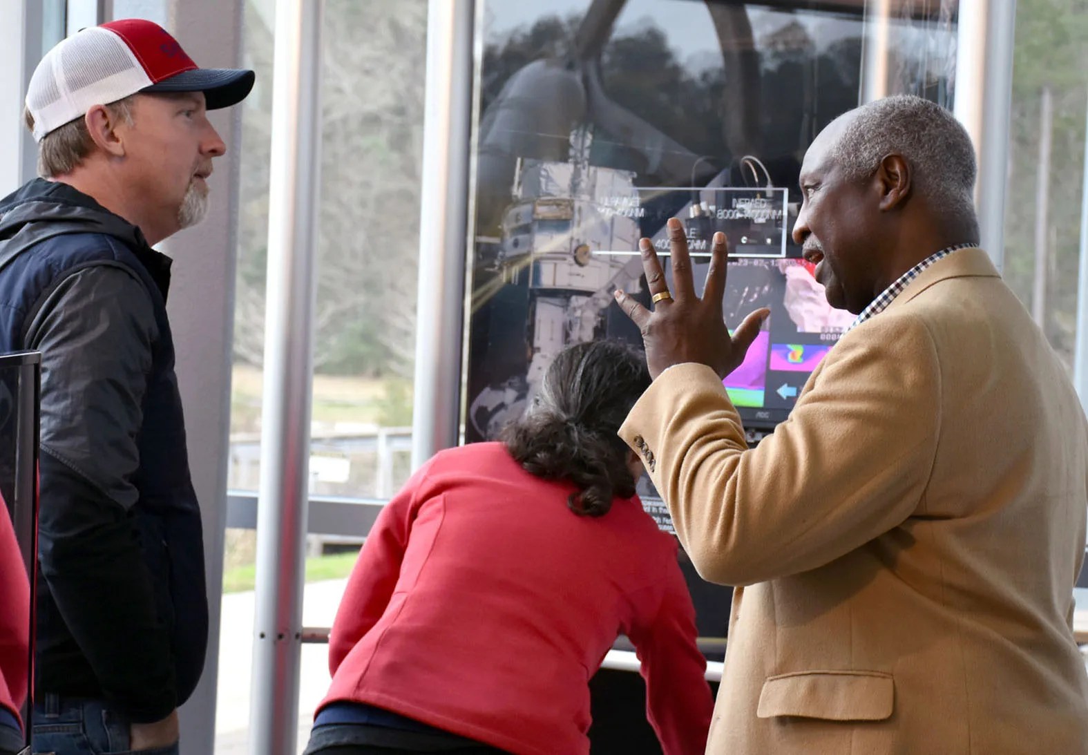 A Hubble team member explains the wavelengths of light to visitors at an interactive light station that is part of the Hubble traveling exhibit.