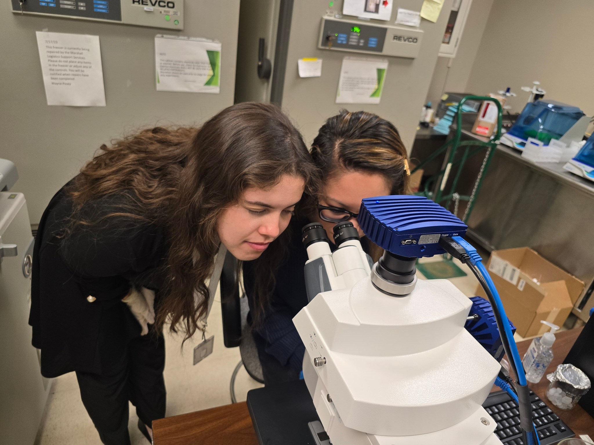 Velez-Justiniano, left, who heads the biofilm mitigation science team at Marshall, looks on as Koellner, right, shows off her latest sample findings.