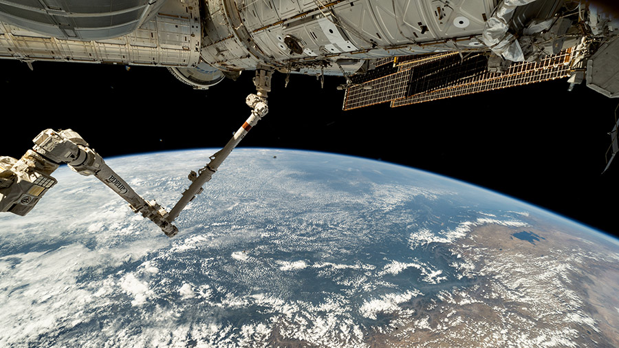 The Canadarm2 robotic arm extends from the Harmony module as the orbital outpost soared above the coast of Peru. Partially obscured in the top background, is the Boeing Starliner spacecraft.