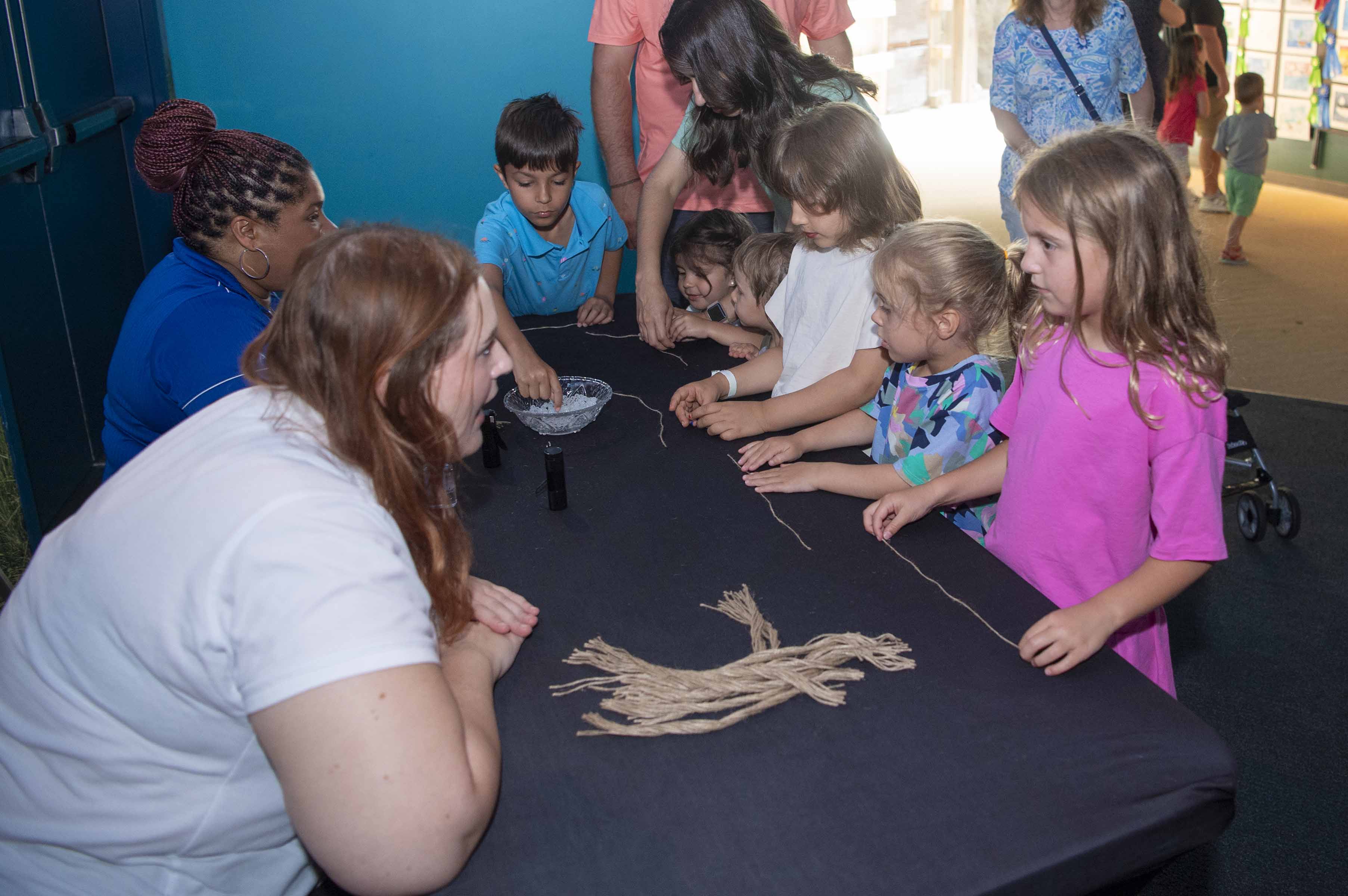 NASA representatives welcome a group of young visitors at Audubon Aquarium