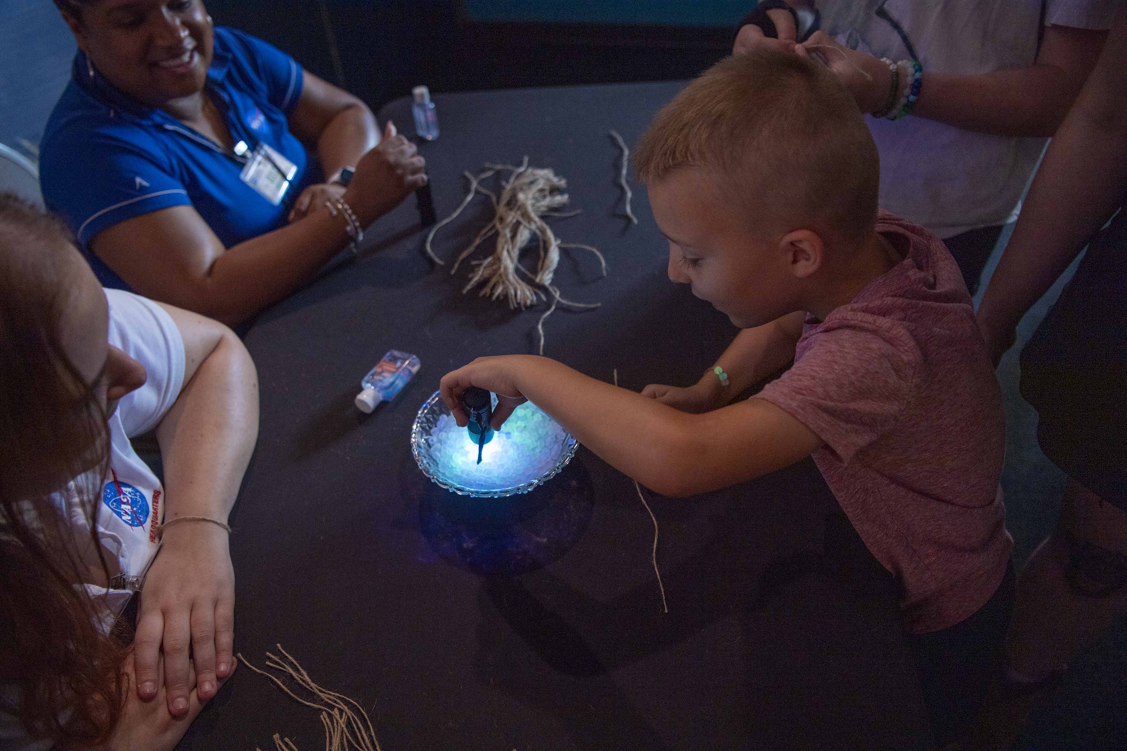 a young Audubon Aquarium visitor experiments with solar beads provided by NASA
