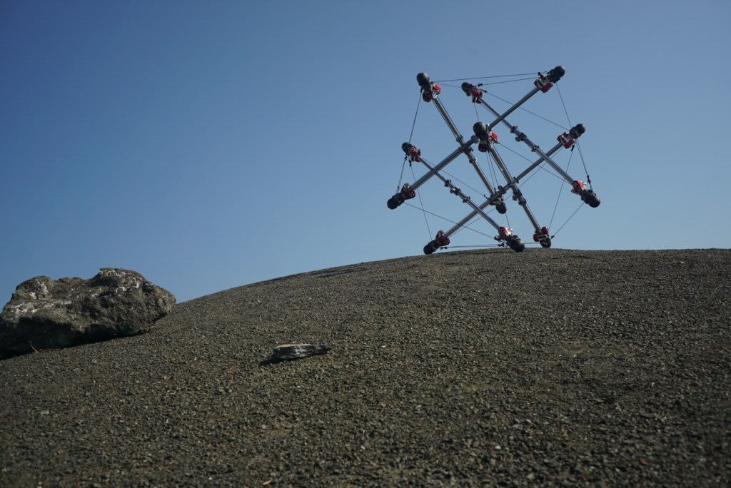 The Super Ball Bot, a tensegrity-based robot, is deployed at the NASA Ames Roverscape.