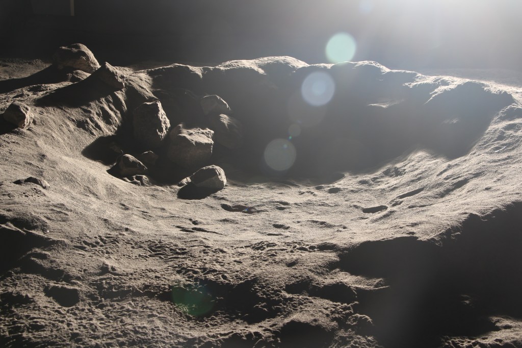A hand shaped crater in the NASA Ames Lunar Lab showing harsh cast shadows and lens flare.