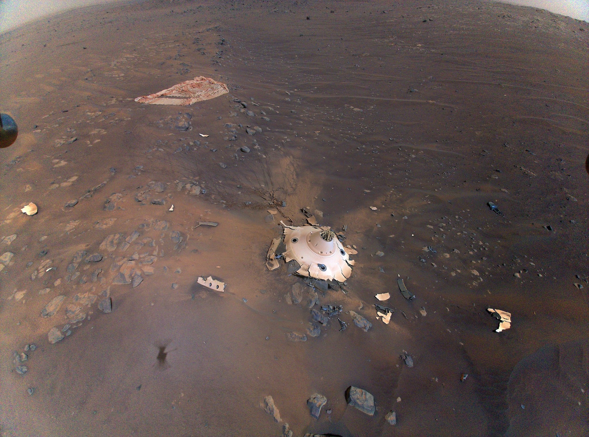 This image of Perseverance's backshell sitting upright on the surface of Jezero Crater was collected from an altitude of 26 feet (8 meters) by NASA's Ingenuity Mars Helicopter during its 26th flight at Mars on April 19, 2022.