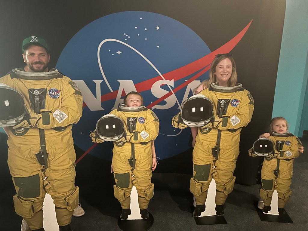 A family of four pose with the astronaut display at the Audubon Aquarium