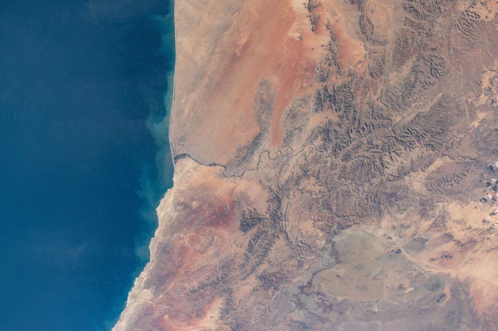 Orange River on the border between South Africa and Namibia on the Atlantic coast and is the termination point of the Namib desert to the north and the desert landscape of Richtersveld to the south. The International Space Station was orbiting 268 miles above at the time of this photograph.