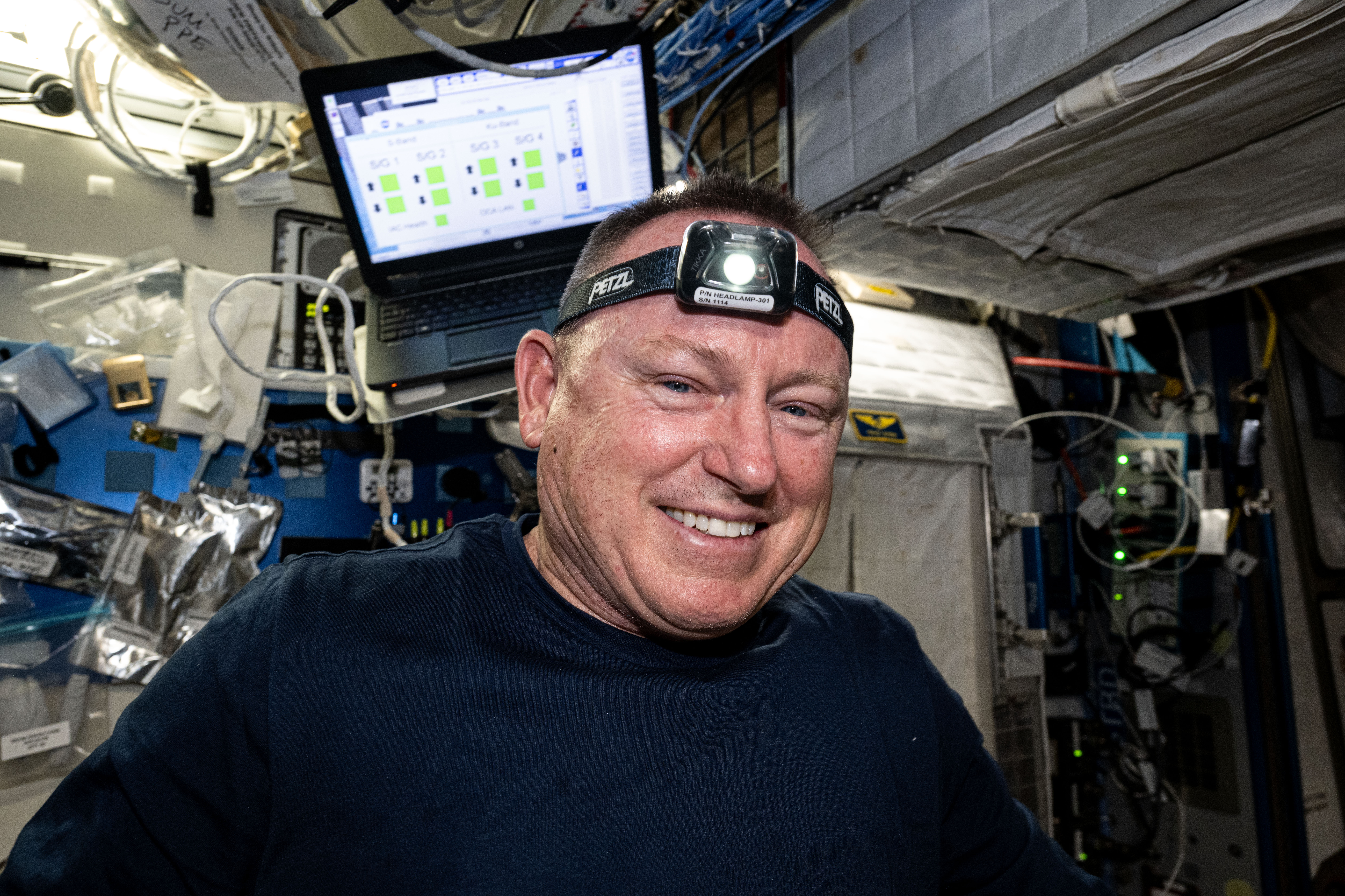 NASA astronaut and Boeing Crew Flight Test Commander Butch Wilmore smiles for a portrait in the middle of orbital maintenance duties aboard the International Space Station's Harmony module.