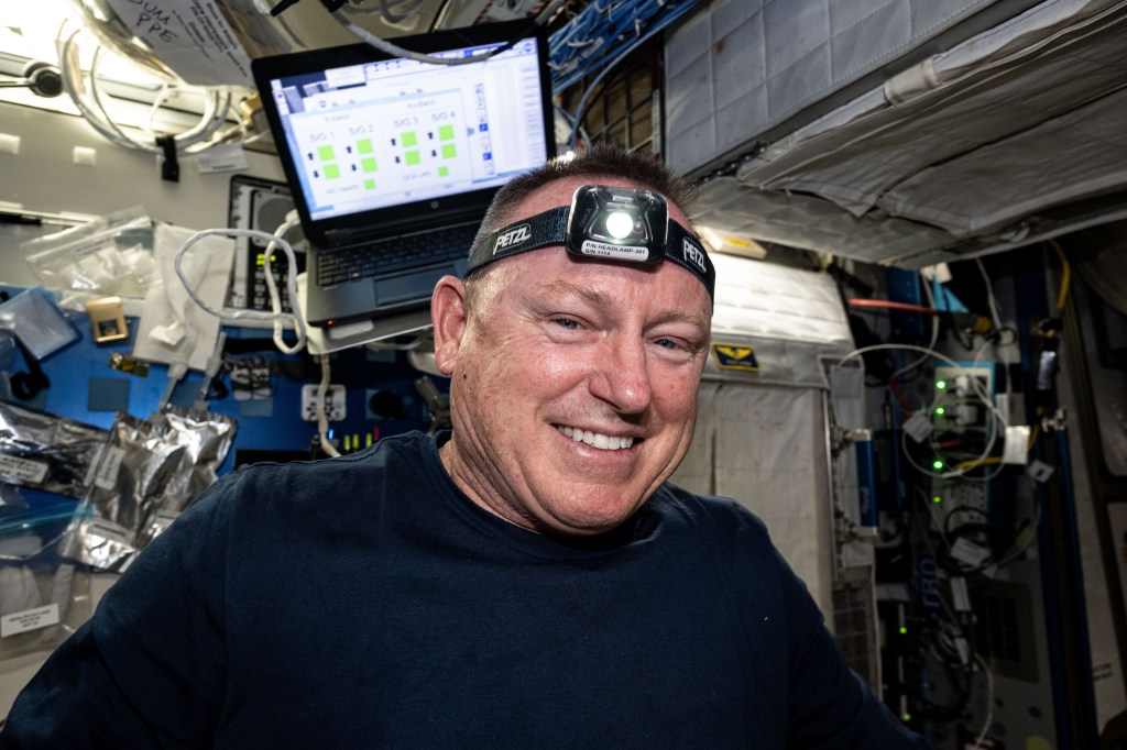 NASA astronaut and Boeing Crew Flight Test Commander Butch Wilmore smiles for a portrait in the middle of orbital maintenance duties aboard the International Space Station's Harmony module.