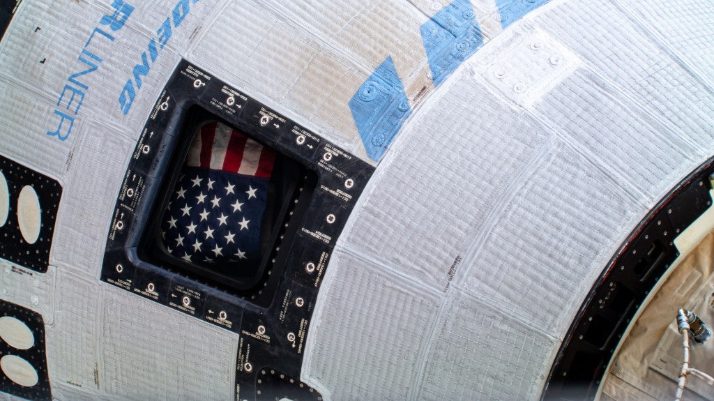 The American flag is pictured inside the window of the Boeing Starliner spacecraft that carried NASA astronauts Butch Wilmore and Suni Williams to the International Space Station on NASA's Boeing Crew Flight Test.
