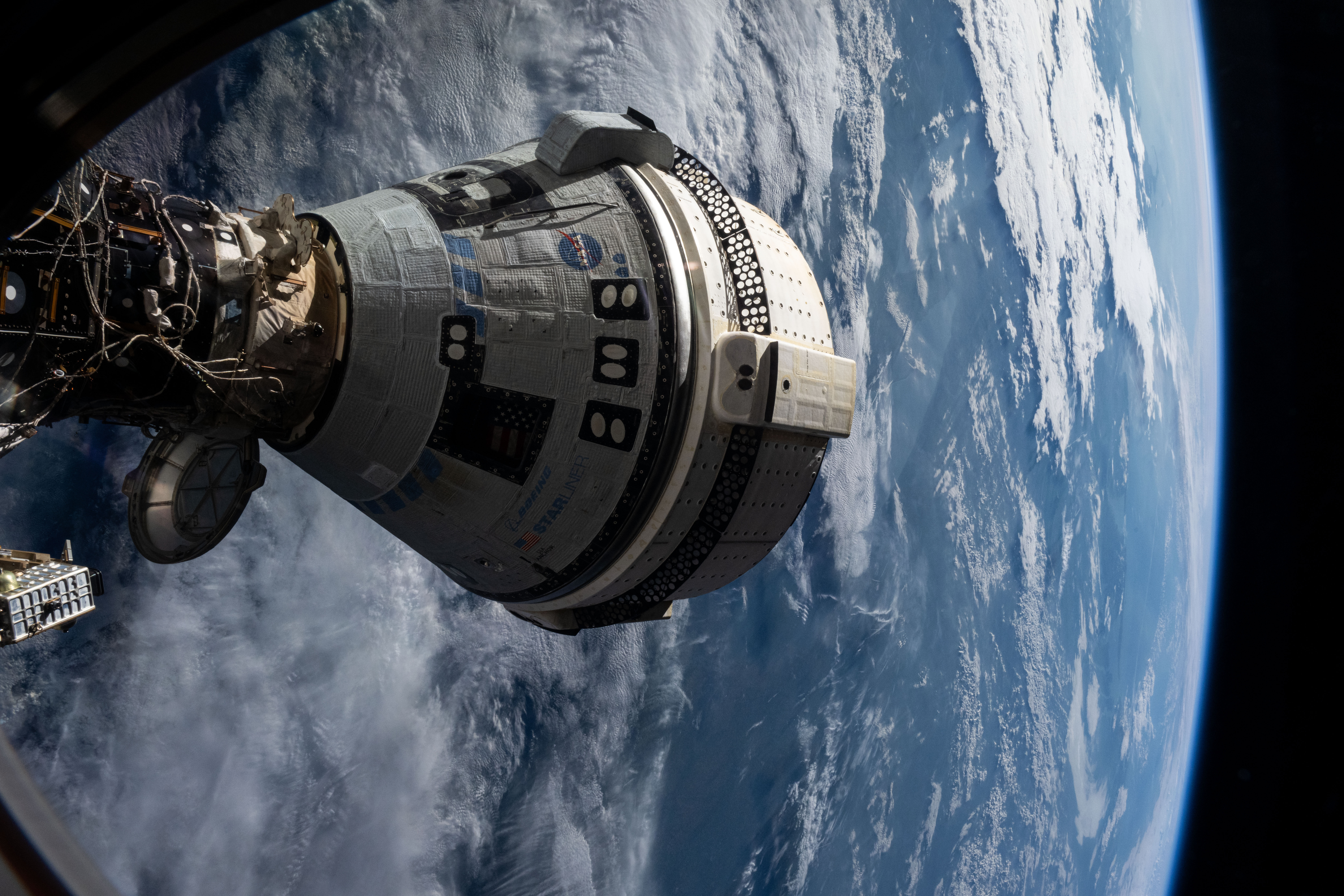 Boeing's Starliner spacecraft that launched NASA's Crew Flight Test astronauts Butch Wilmore and Suni Williams to the International Space Station is pictured docked to the Harmony module's forward port. This view is from a window on the SpaceX Dragon Endeavour spacecraft docked to the port adjacent to the Starliner.