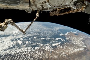 The 57.7-foot-long Canadarm2 robotic arm extends from the International Space Station's Harmony module as the orbital outpost soared 261 miles above the coast of Peru. Partially obscured in the top background, is the Boeing Starliner spacecraft docked to Harmony's forward port.