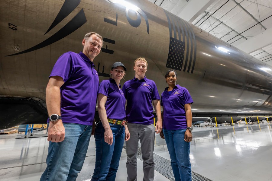 NASAâs SpaceX Crew-9 stands in front of a Falcon 9 first-stage booster at SpaceXâs HangarX facility in Florida.