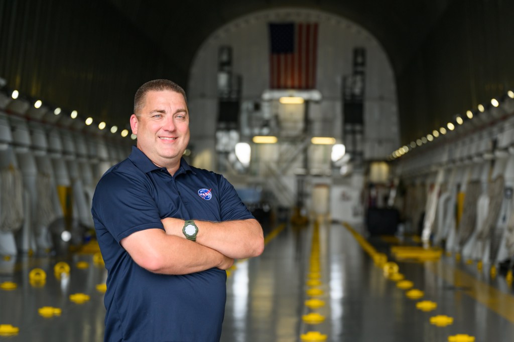 John Campbell, a logistics engineer at NASA’s Marshall Space Flight Center, stands on NASA's Pegasus barge July 15 for the Artemis II core stage rollout.