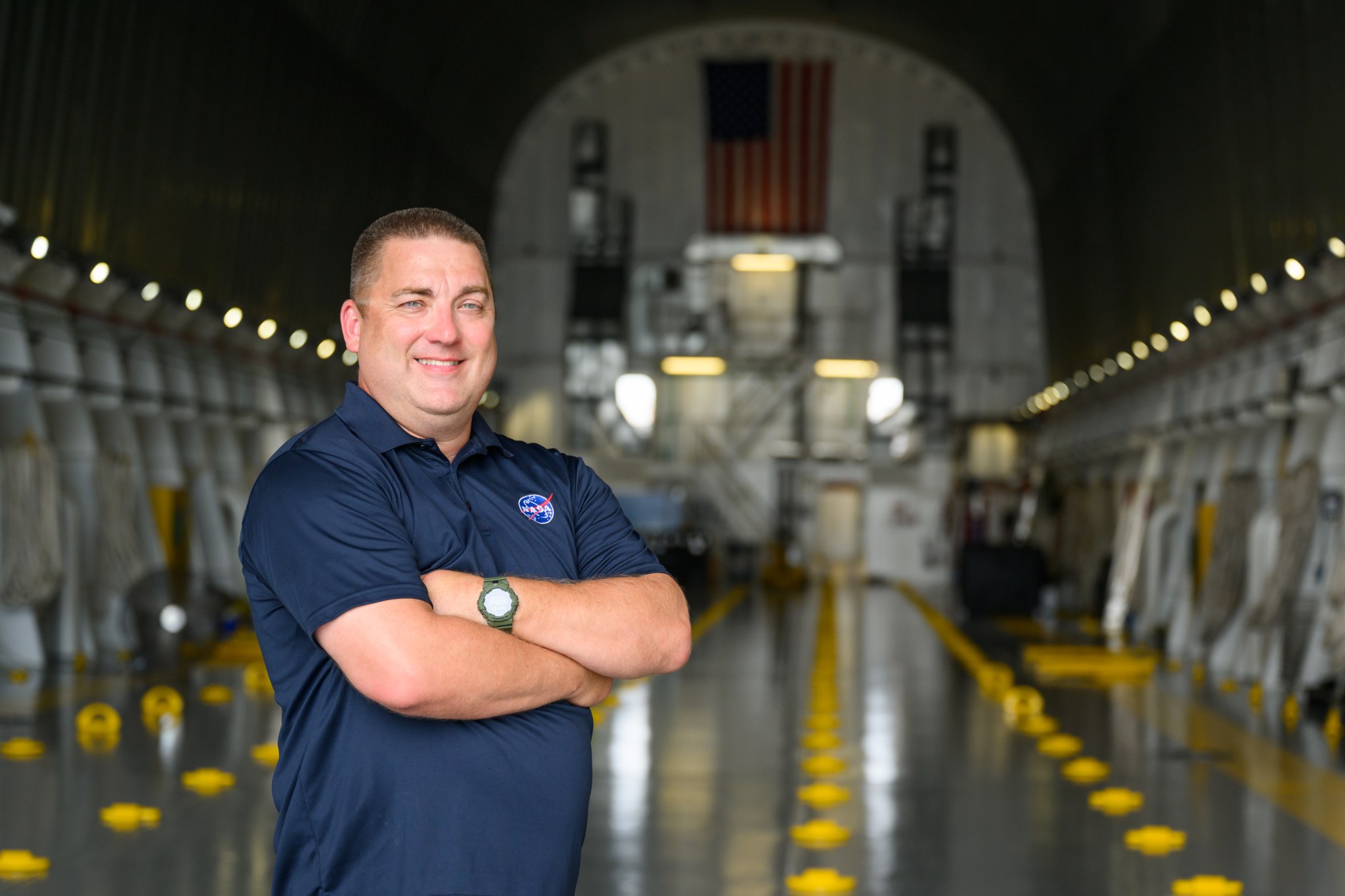 John Campbell, a logistics engineer at NASA’s Marshall Space Flight Center, stands on NASA's Pegasus barge July 15 for the Artemis II core stage rollout.