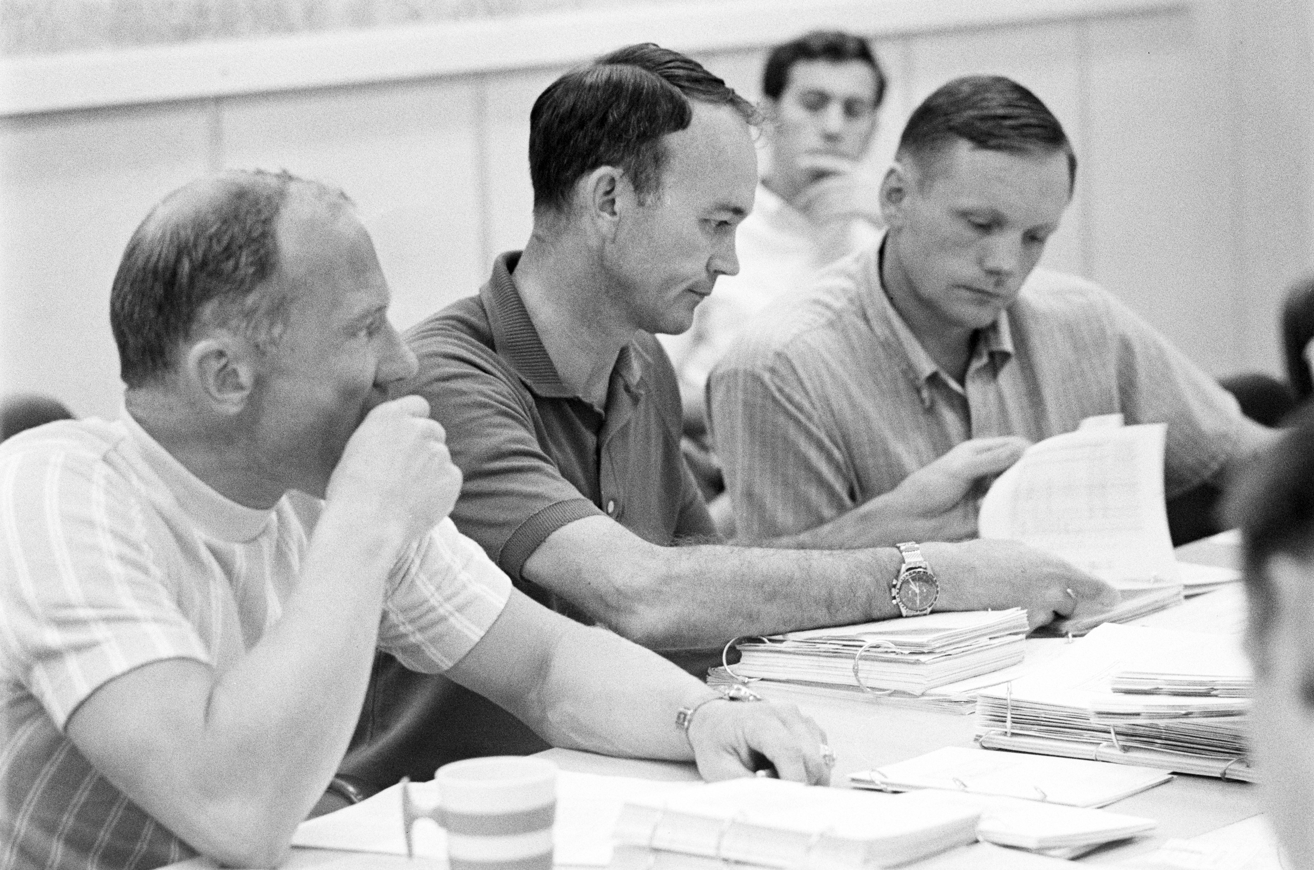 Buzz, Mike, and Neil study their flight plans one more time