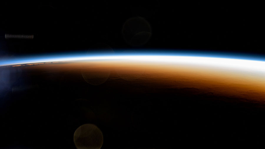 An orbital sunrise colorfully illuminates the Earth's atmosphere and highlights the boundary between night and day, also known as the terminator, in this photograph from the space station.