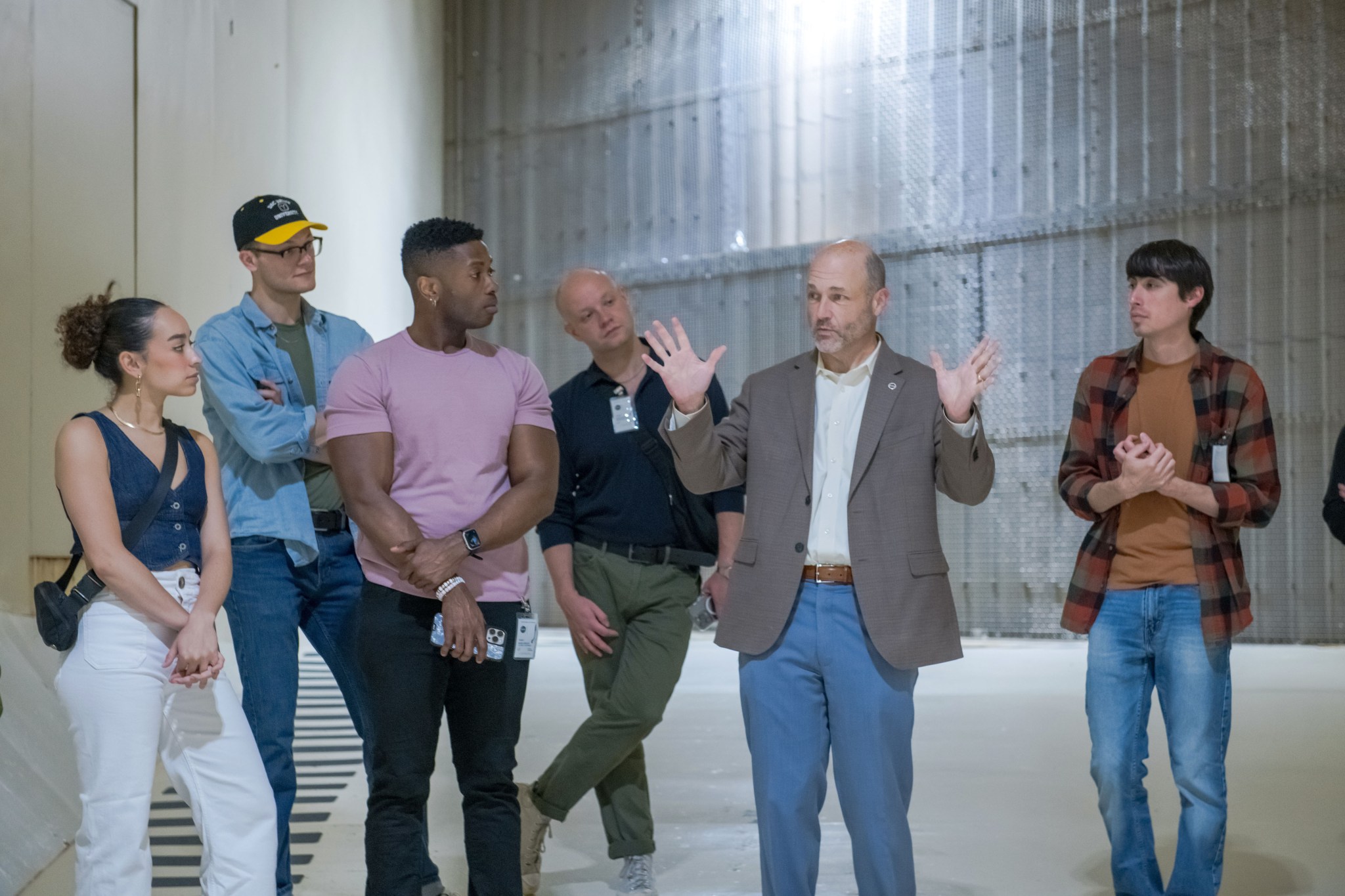 Back to the Future: The Musical cast and crew members gather around NASA Glenn Research Center Director Dr. Jimmy Kenyon, who holds his hands up to explain features of the Icing Research Tunnel.