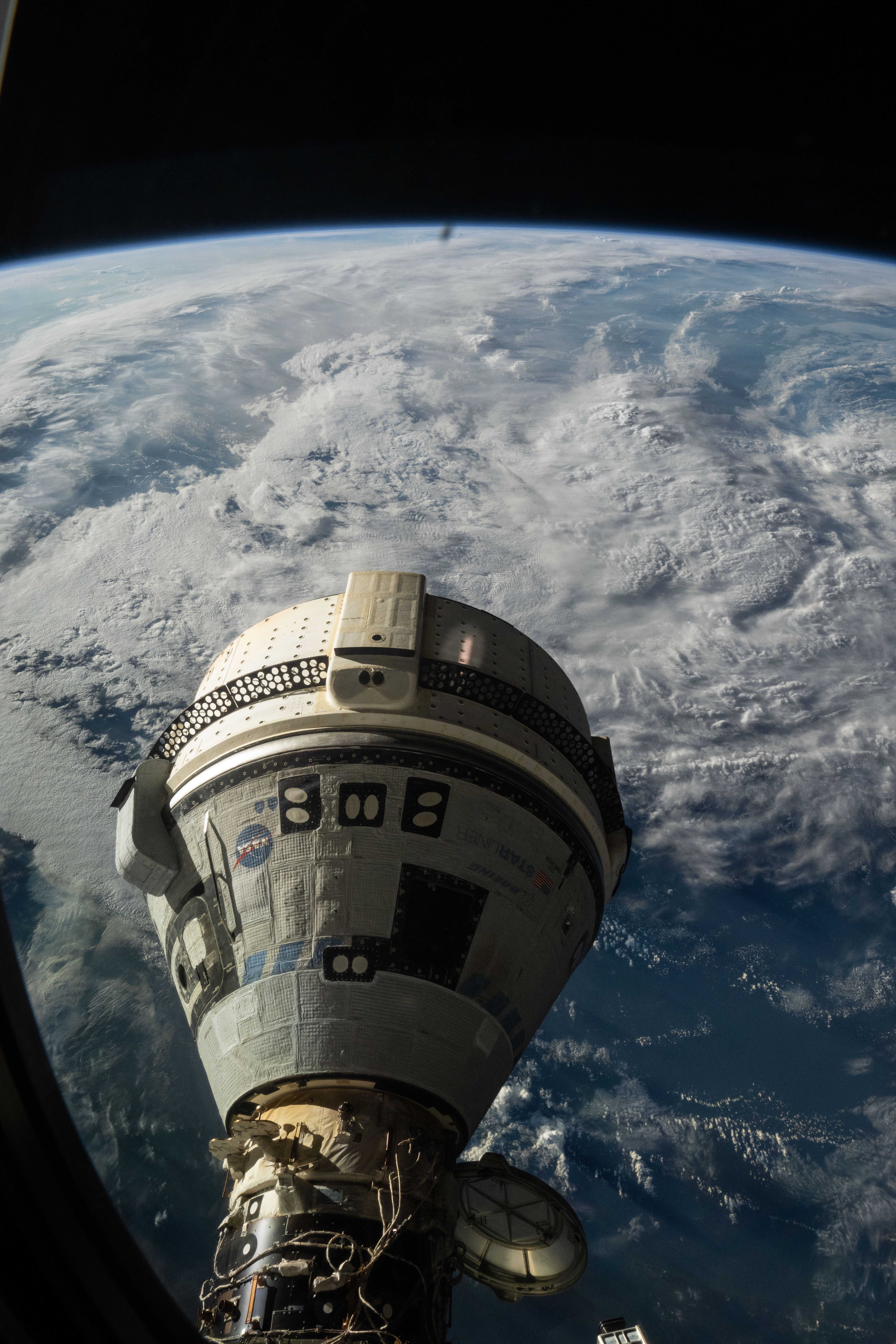 Boeing's Starliner spacecraft is pictured docked to the International Space Station's forward port on the Harmony module. NASA astronaut Mike Barratt photographed Starliner from a window on the SpaceX Dragon Endeavour spacecraft.