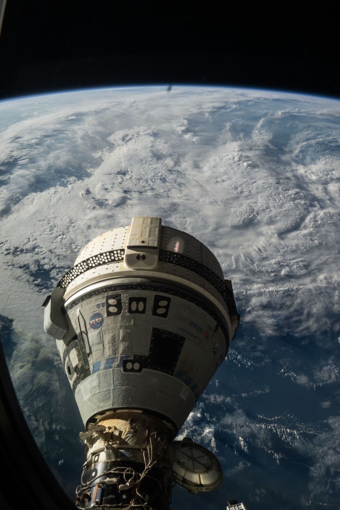 Boeing's Starliner spacecraft is pictured docked to the International Space Station's forward port on the Harmony module. NASA astronaut Mike Barratt photographed Starliner from a window on the SpaceX Dragon Endeavour spacecraft.