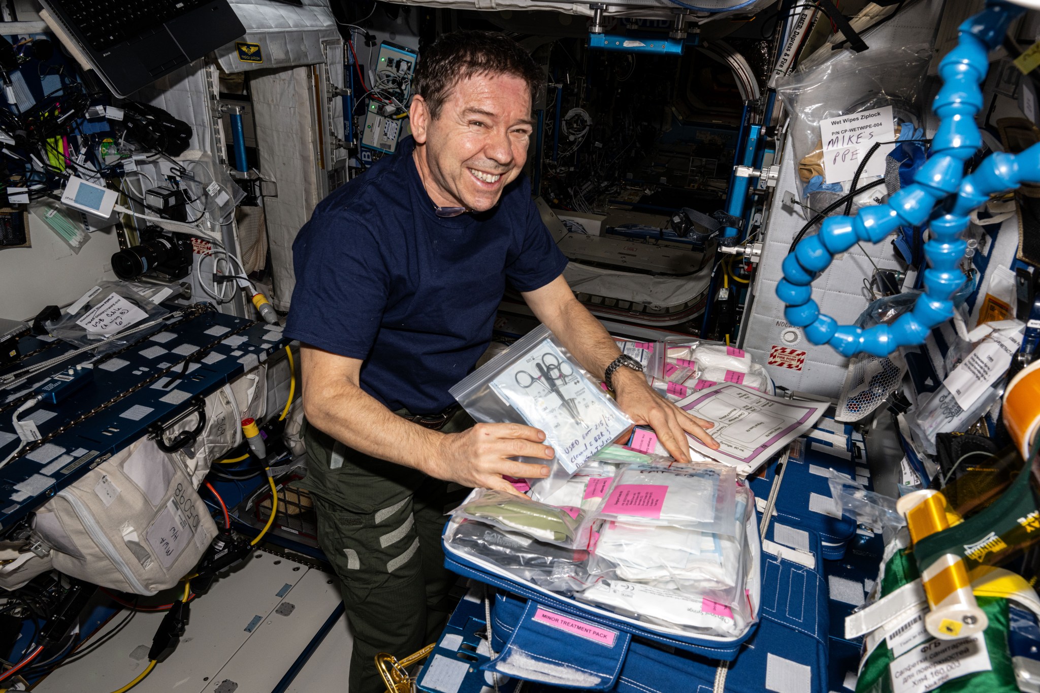 NASA astronaut and Expedition 71 Flight Engineer Mike Barratt collects and organizes medical supplies aboard the International Space Station's Harmony module.