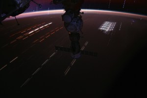 This long-duration photograph of the Soyuz MS-25 spacecraft with light trails on Earth below and stars trails above the horizon was taken by NASA astronaut Matthew Dominick as the International Space Station soared 262 miles above a sparsely populated region of Queensland, Australia.