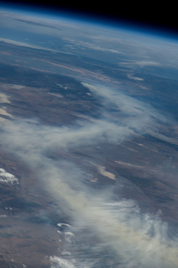 A wildfire in Canada and its smoke spreading in the atmosphere are pictured from the Intenational Space Station as it orbited 263 miles above North Dakota.