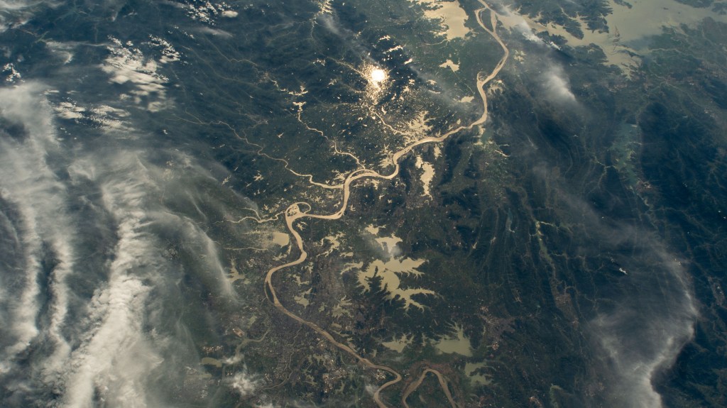 The Yangtze River beams in the Sun's glint as wildfires burn in the surrounding forestland near the city of Wuhan in China's province of Hubei. The International Space Station was orbiting 262 miles above the Asian nation at the time of this photograph.