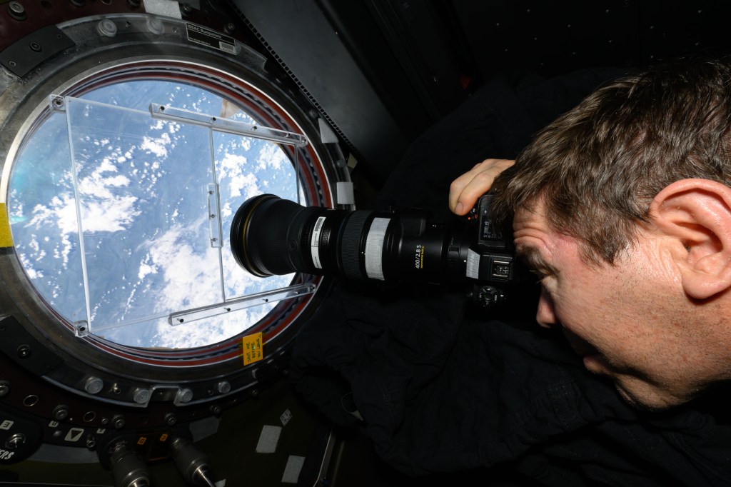 NASA astronaut and Expedition 71 Flight Engineer Mike Barratt points a camera out a window on the International Space Station's Destiny laboratory and photographs landmarks on Earth. The orbital outpost was soaring 258 miles above China near Hong Kong on the coast of the South China Sea at the time of this photograph.