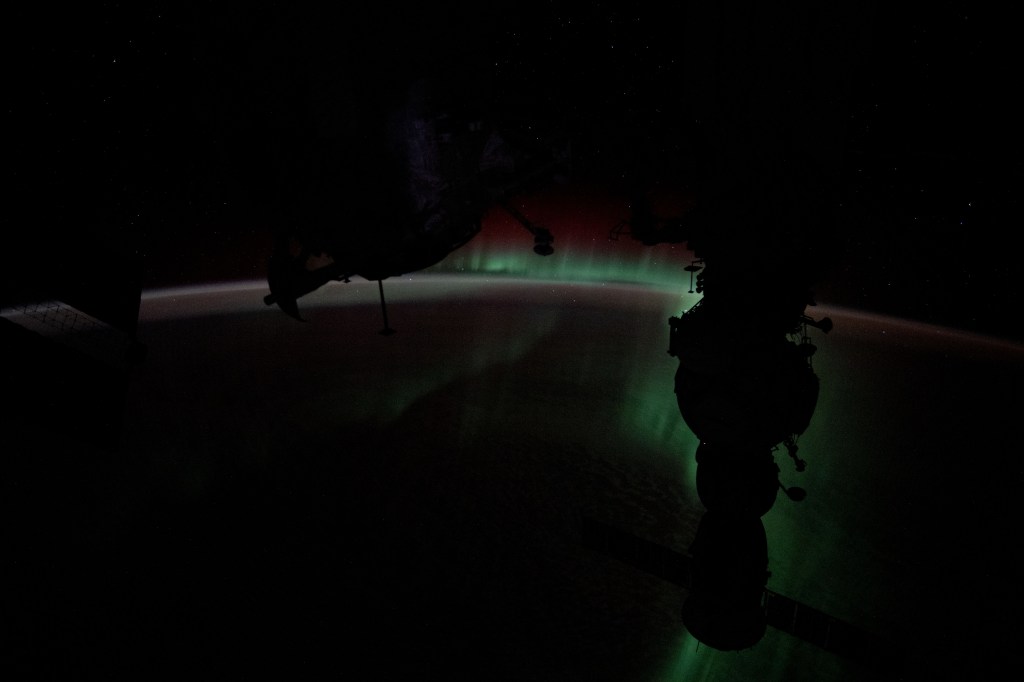 The Aurora Australis silhouettes the Soyuz MS-25 crew ship in this photograph from the International Space Station as it soared 272 miles above the Indian Ocean halfway between Australia and Antarctica.