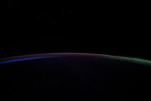A dim Aurora Australis (at right) blankets the Earth's horizon and fades into a dawning orbital sunrise in this photograph from the International Space Station as it orbited 263 miles above the Pacific Ocean southeast of New Zealand.