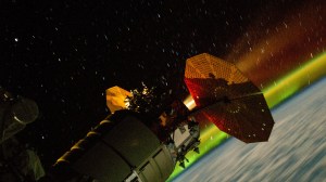 This long-duration photograph taken with a station camera uses increased sensitivity and shows the Northrop Grumman Cygnus space freighter firing its engine to raise the International Space Station's orbital altitude. The reboosts counteract atmospheric drag and prepare for the space station upcoming spacecraft activities. The orbital outpost was soaring 263 miles above the Indian Ocean with a field of star trails above and the Aurora Australis below.