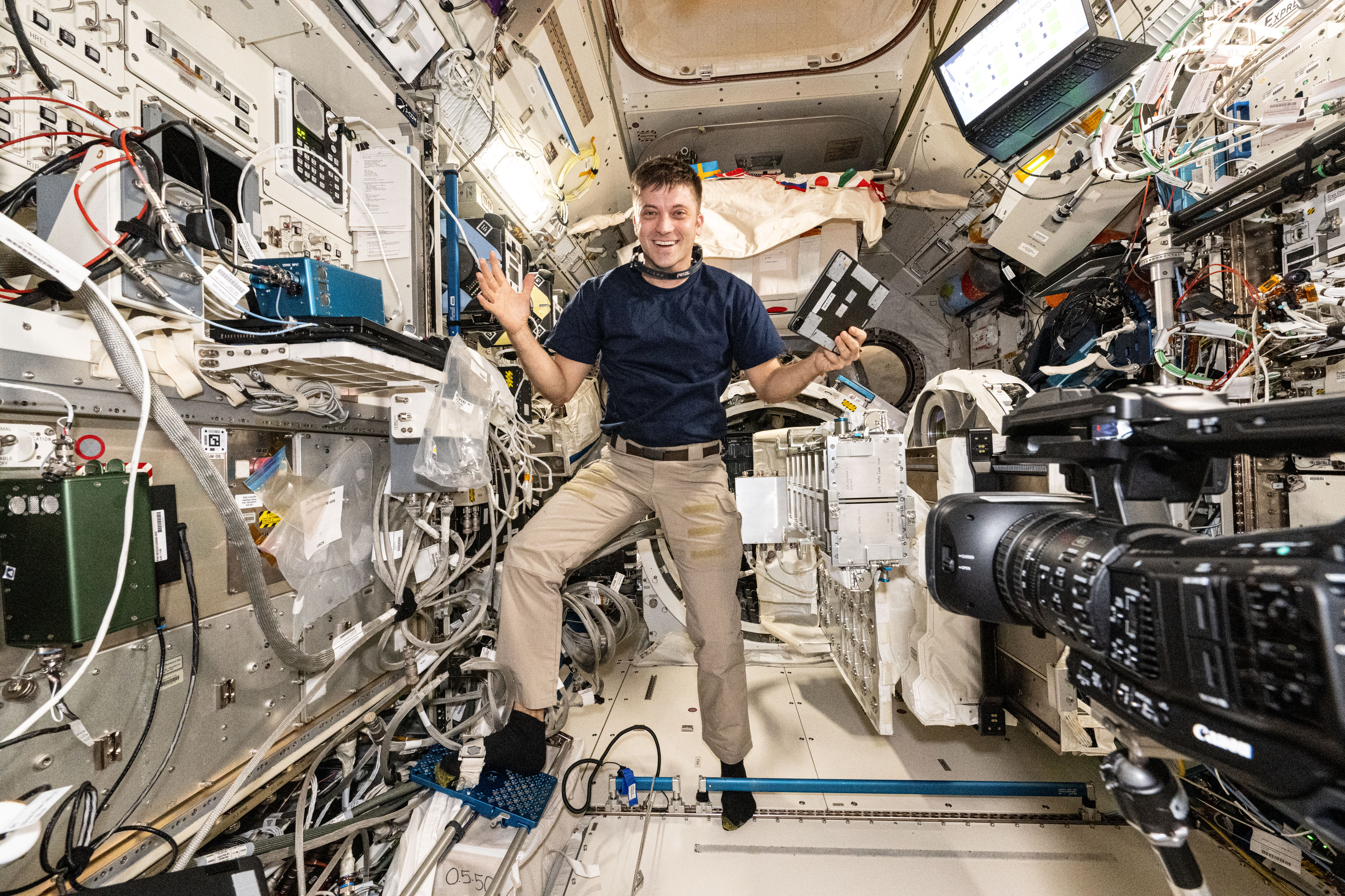 NASA astronaut and Expedition 71 Flight Engineer Matthew Dominick smiles for a portrait in the middle of maintenance work aboard the International Space Station's Kibo laboratory module.