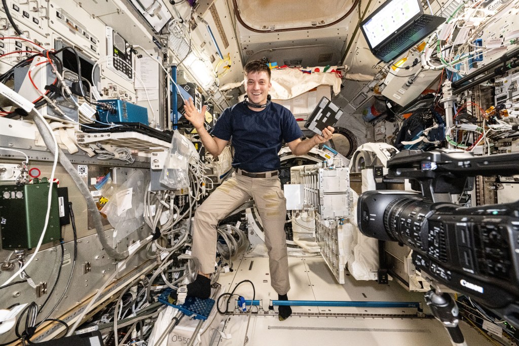 NASA astronaut and Expedition 71 Flight Engineer Matthew Dominick smiles for a portrait in the middle of maintenance work aboard the International Space Station's Kibo laboratory module.