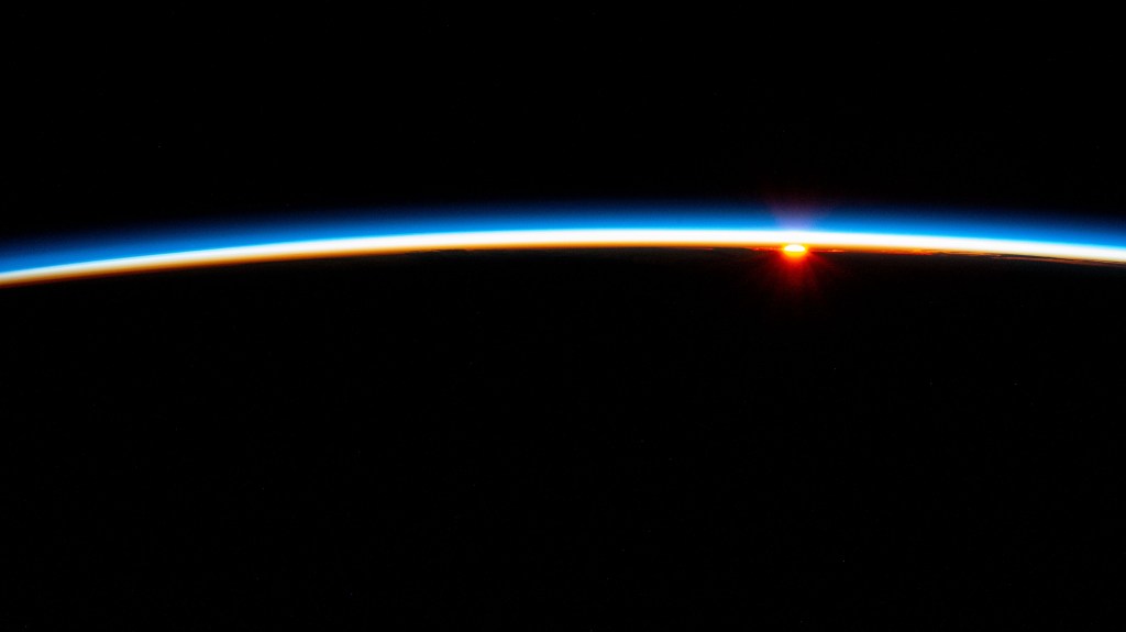 The last rays of an orbital sunset fade below Earth's horizon illuminating the atmosphere in this photograph from the International Space Station as it soared 267 miles above the South Atlantic Ocean in between the tips of South America and South Africa..