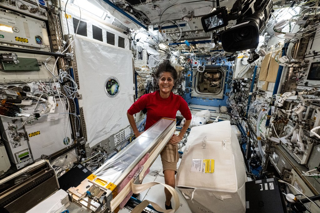 NASA astronaut and Boeing's Crew Flight Test Pilot Suni Williams smiles for a portrait in the middle of maintenance work aboard the International Space Station's Kibo laboratory module.