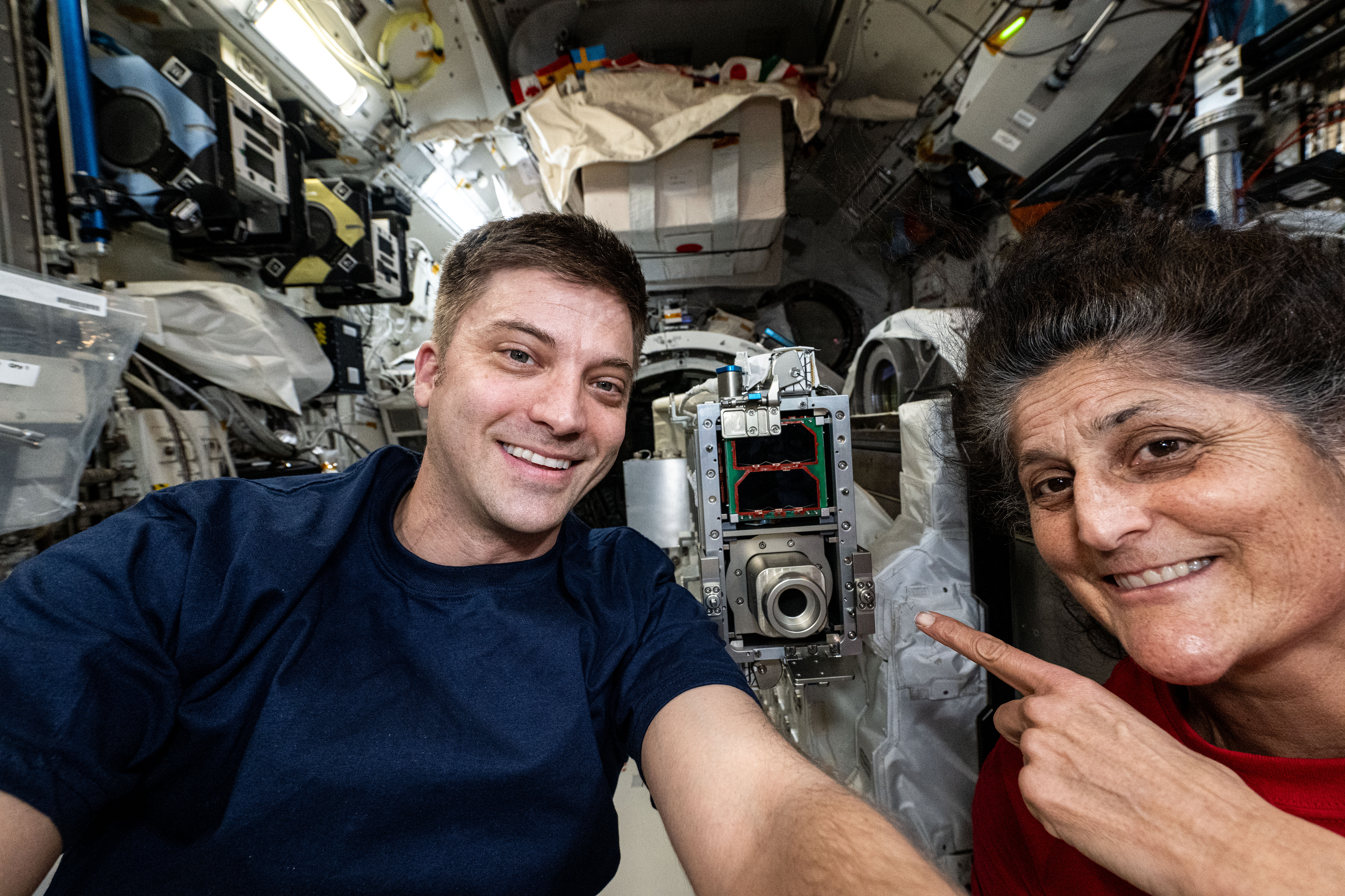 NASA astronauts Matthew Dominick, Expedition 71 Flight Engineer, and Suni Williams, Boeing's Crew Flight Test Pilot, smile for a selfie portrait aboard the International Space Station's Kibo laboratory module.