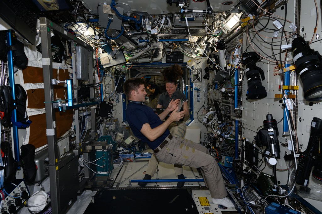 iss071e547737 (Aug. 14, 2024) --- NASA astronauts Matthew Dominick and Tracy C. Dyson, both Expedition 71 Flight Engineers, review maintenance procedures on computer tablets inside the International Space Station's Destiny laboratory module.