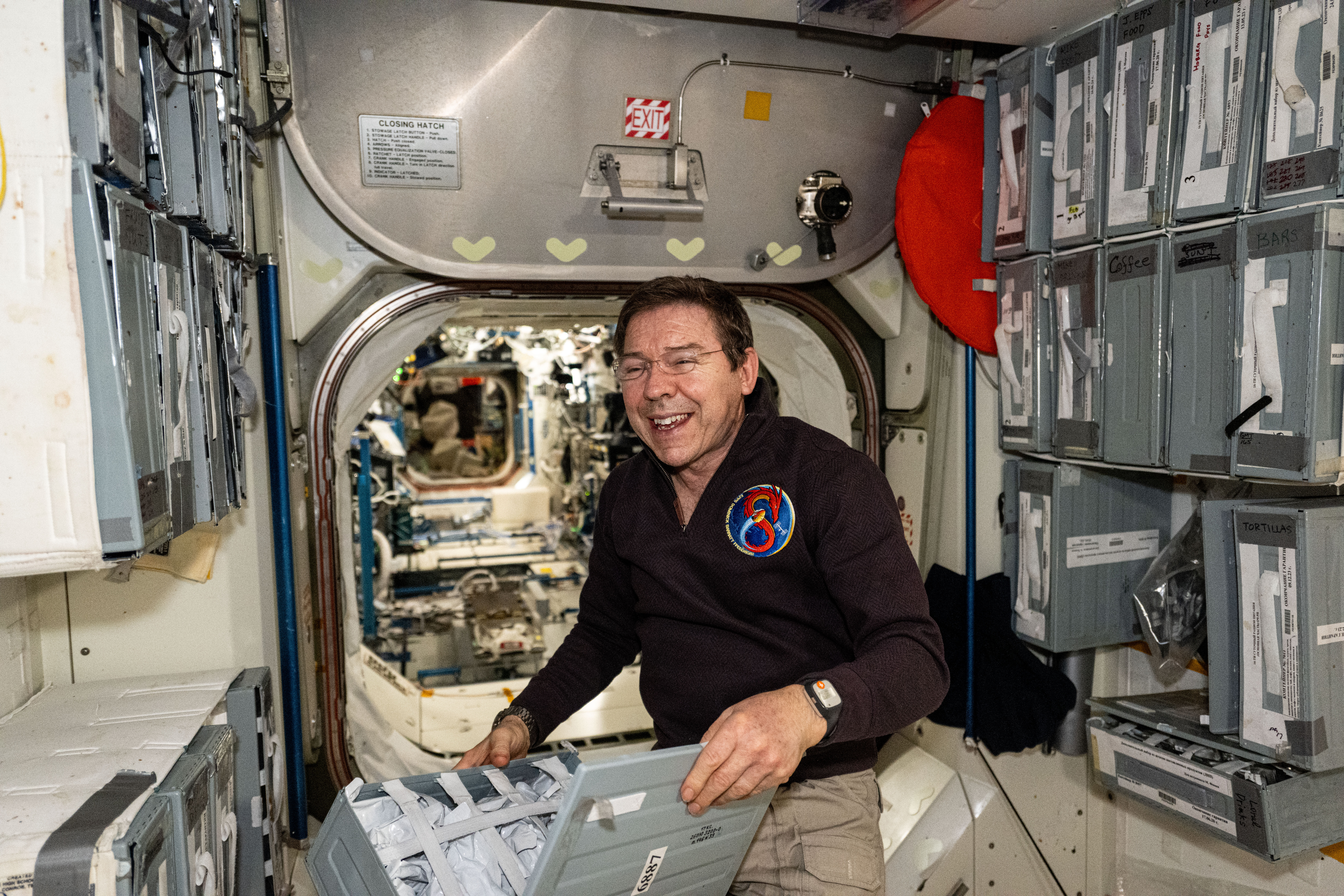 NASA astronaut and Expedition 71 Flight Engineer Mike Barratt checks food packs in the Unity module's galley aboard the International Space Station.