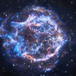 This image features the Cassiopeia A supernova, an expanding ball of matter and energy ejected from an exploding star. Here, rings of neon blue and brilliant white emit veins of polished gold. The rings and their arching veins encircle a place of relative calm at the center of the supernova remnant. This hole at the center of the circle, and the three-dimensionality conveyed by the rings and their arching veins, give this image of Cassiopeia A the look of a giant, crackling, electric blue donut. X-rays detected by Chandra show debris from the destroyed star and the blast wave from the explosion.