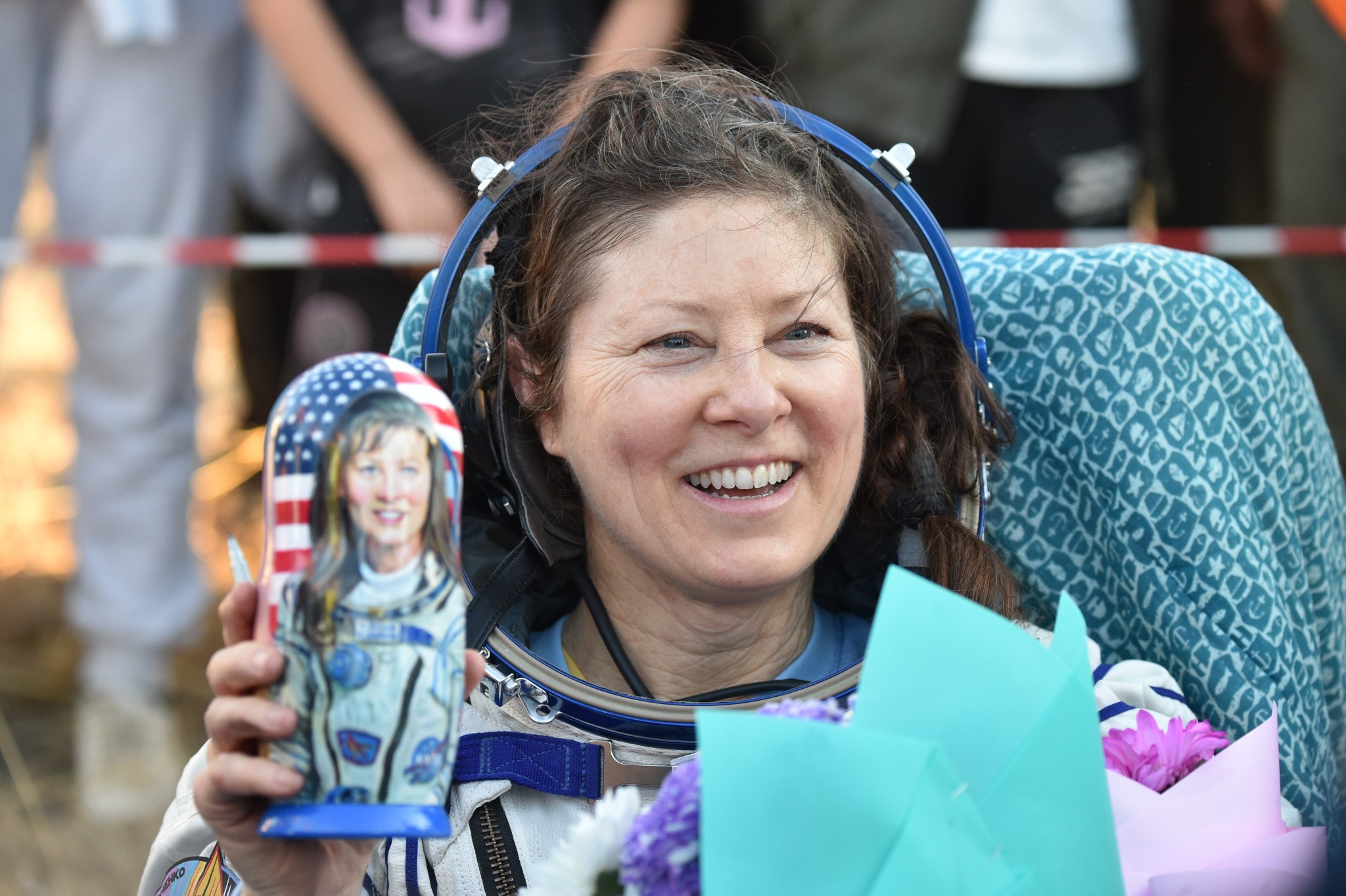 NASA astronaut Tracy C. Dyson is seen smiling and holding a gifted matryoshka doll outside the Soyuz MS-25 spacecraft after she landed with Roscosmos cosmonauts Oleg Kononenko and Nikolai Chub,