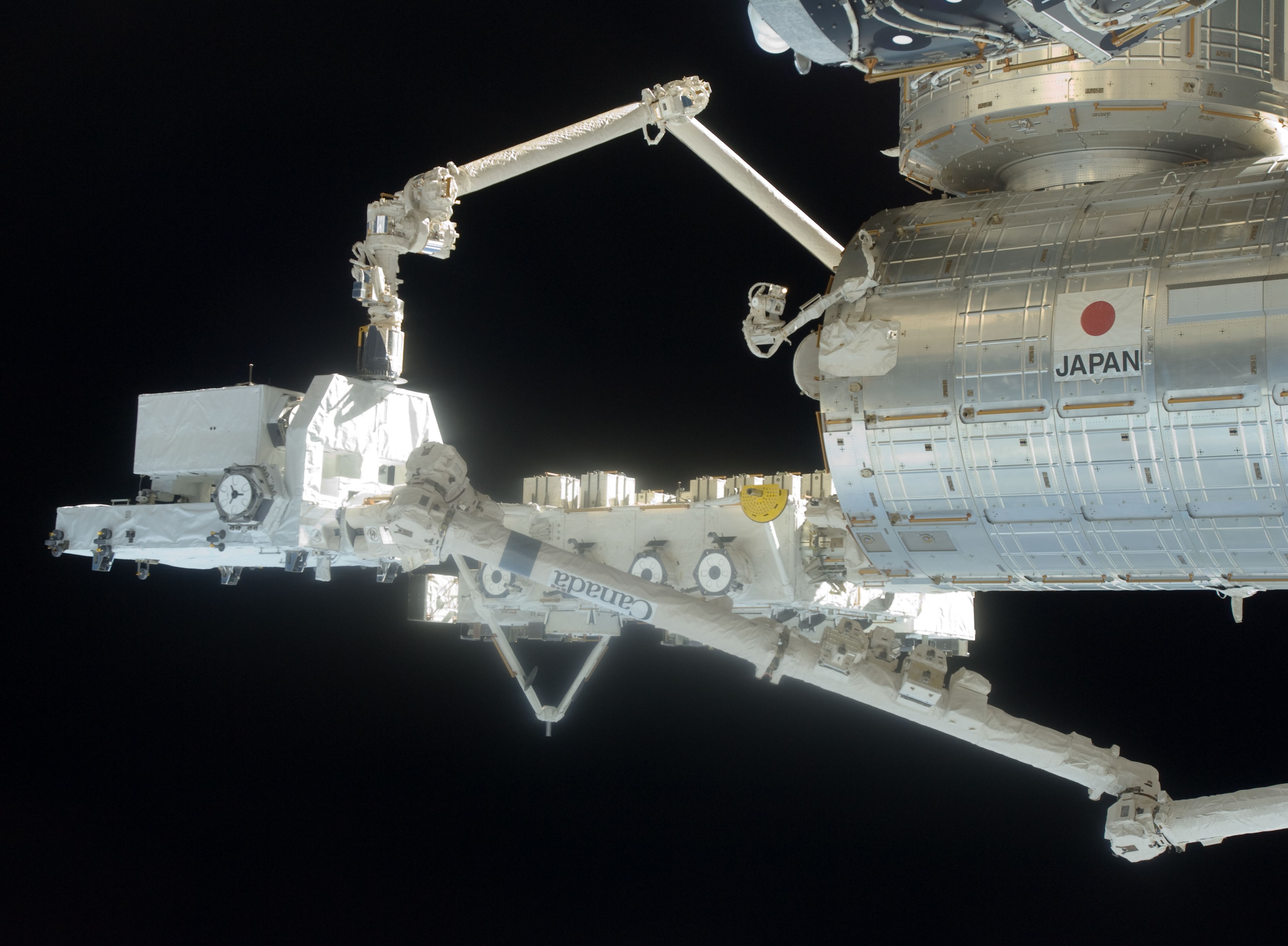 The Japanese robotic arm grapples one of the payloads from the Exposed Pallet (EP) to transfer it to the Japanese Experiment Module-Exposed Facility (JEM-EF)