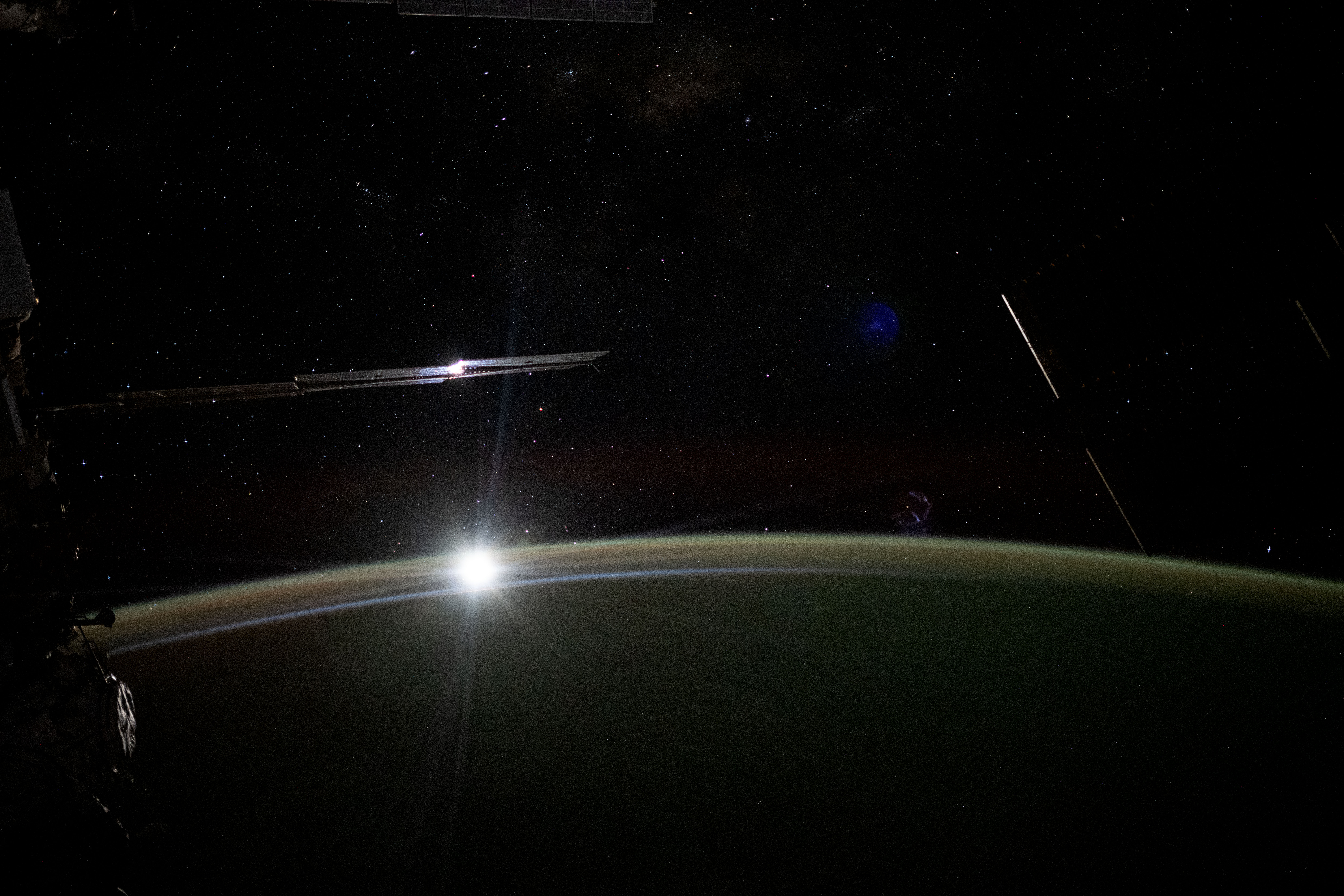 The Moon sets behind Earth's horizon illuminating the atmosphere in this long-duration photograph taken with a camera programmed for high sensitivity aboard the International Space Station as it orbited 265 miles above the Pacific Ocean.
