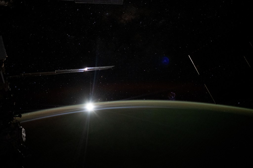 The Moon sets behind Earth's horizon illuminating the atmosphere in this long-duration photograph taken with a camera programmed for high sensitivity aboard the International Space Station as it orbited 265 miles above the Pacific Ocean.