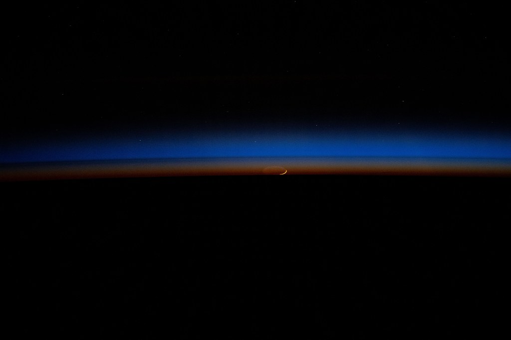 iss071e609208 (Sept. 4, 2024) -- The Moon rises through a sunset in Earth's horizon casting blue and orange hues as the International Space Station orbited 257 miles above India.