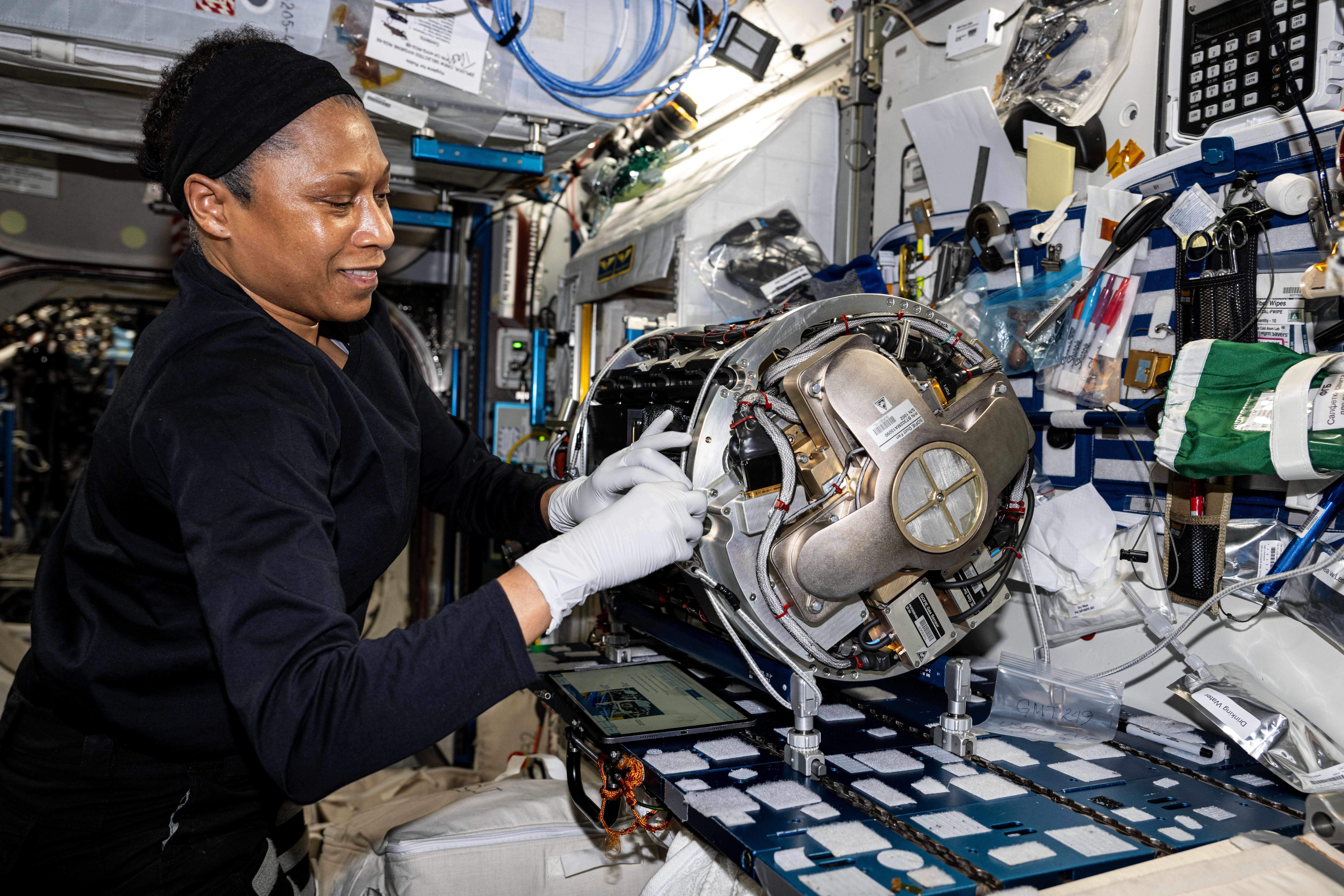 NASA astronaut and Expedition 71 Flight Engineer Jeanette Epps swaps research components and removes samples from inside the Combustion Integrated Rack for a series of experiments exploring space flammability and fire suppression in microgravity.