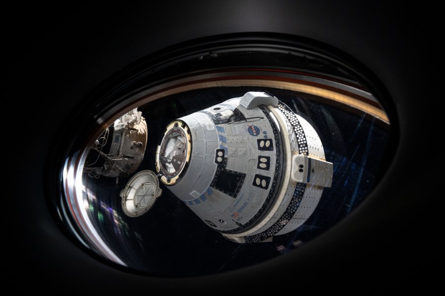 Boeing's uncrewed Starliner spacecraft is pictured from a window aboard the SpaceX Dragon Endeavour spacecraft shortly after undocking from the International Space Station's forward port on the Harmony module.