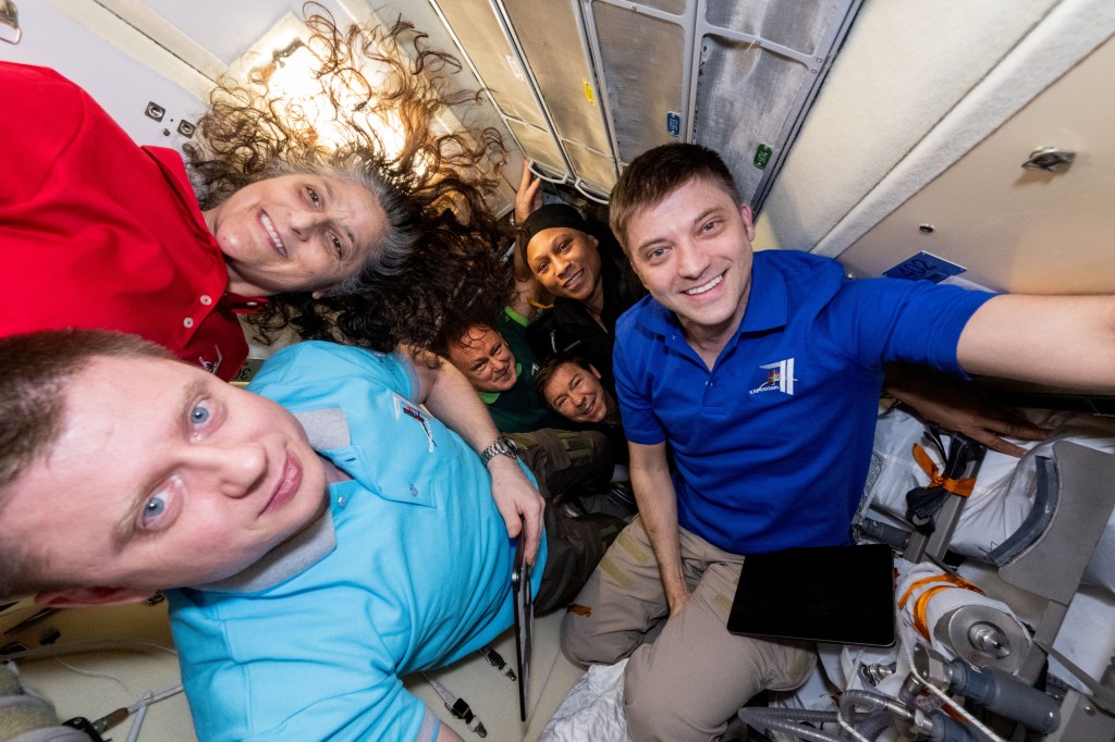 Expedition 71 crew members (clockwise from bottom left) Alexander Grebenkin, from Roscosmos, and NASA astronauts Suni Williams, Jeanette Epps, Matthew Dominick, Mike Barratt, and Butch Wilmore, pose for a portrait inside the International Space Station's Rassvet module.
