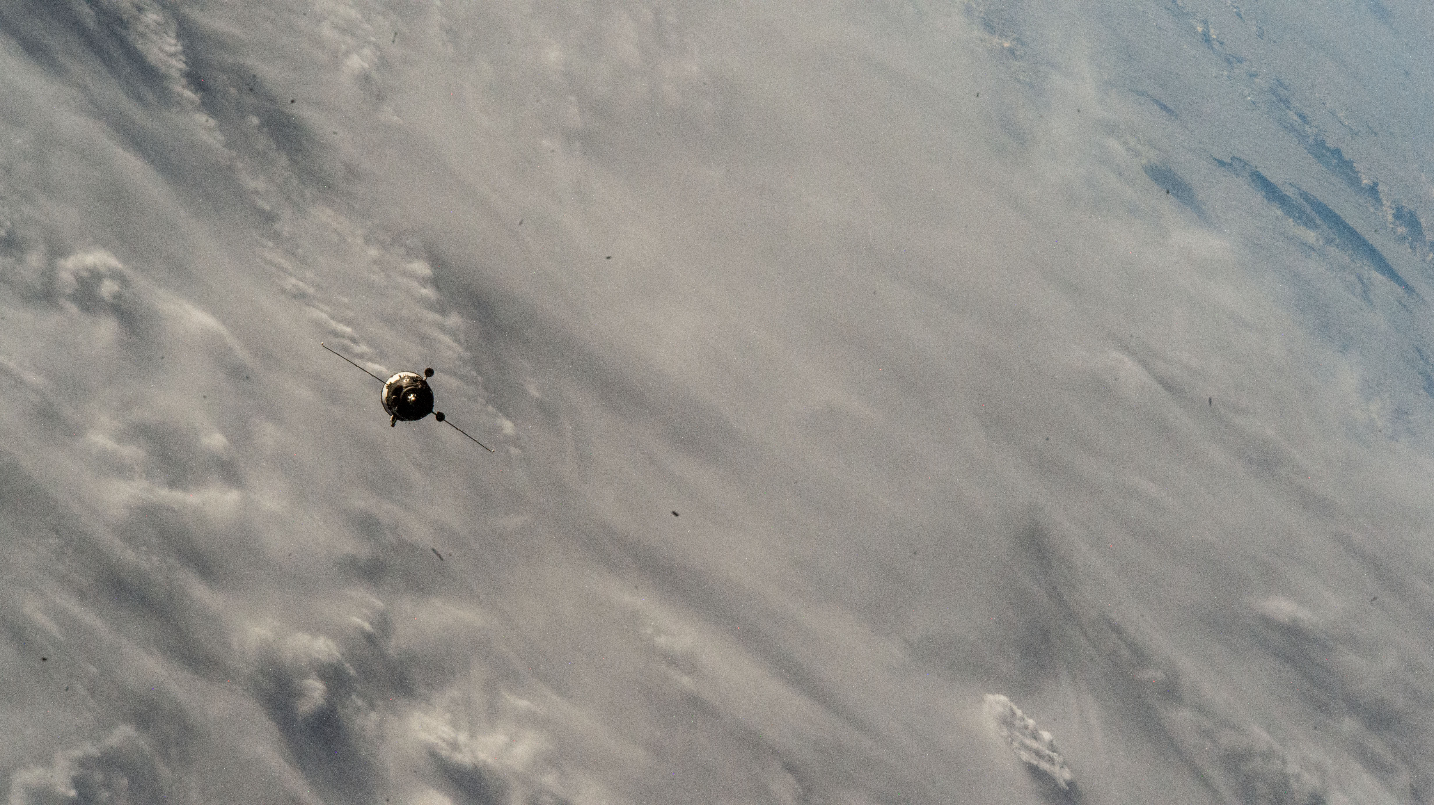 The Soyuz MS-26 spacecraft carrying NASA astronaut Don Pettit and Roscosmos cosmonauts Alexey Ovchinin and Ivan Vagner approaches the International Space Station 258 miles above a cloudy Atlantic Ocean.
