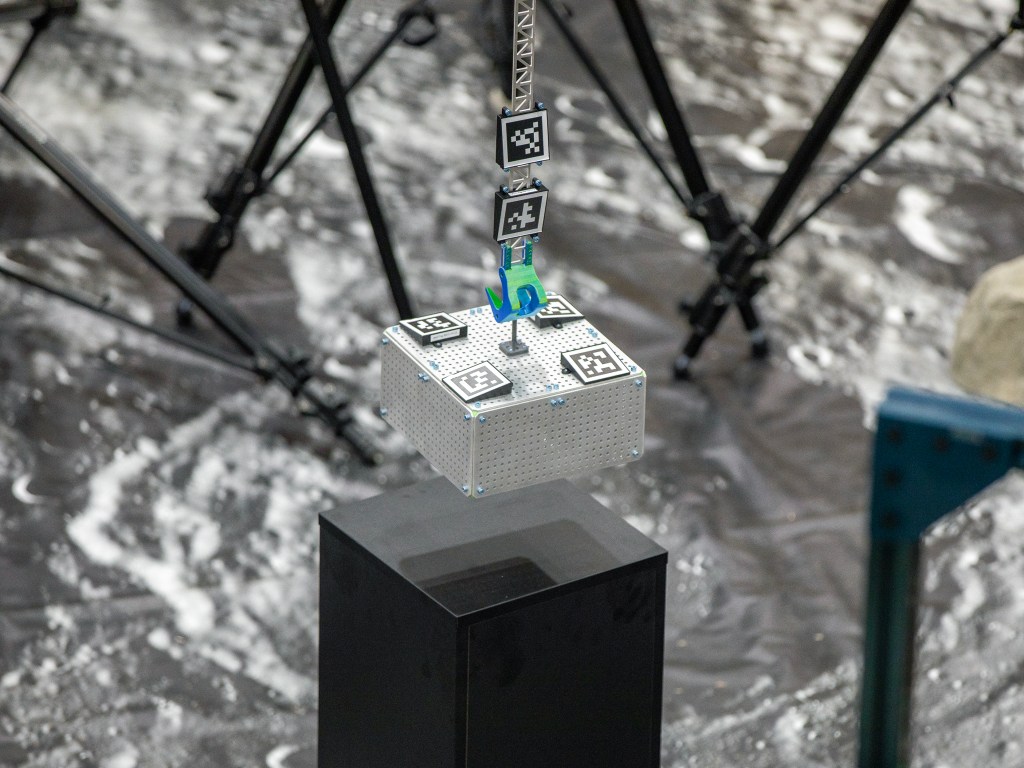 The LANDO system works by using onboard sensors to scan encoded markers (similar to a QR code) on a payload, which will reveal critical information about its position and orientation relative to the LSMS. This information is used to calculate where the robotic arm exists in space and plan the motion path to pick up and move payloads.